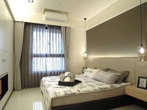 主臥的空間設計以白色、米色、淺灰色為基調，呈現簡潔的放鬆感。